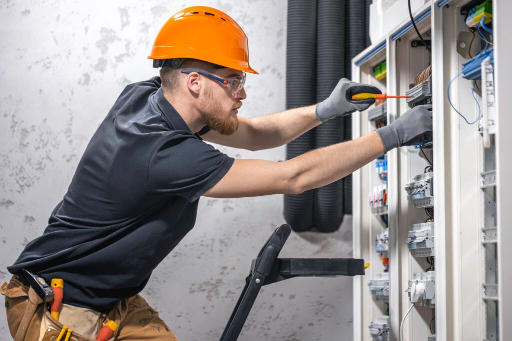 electricista masculino trabajando en una caja para instalar un ascensor